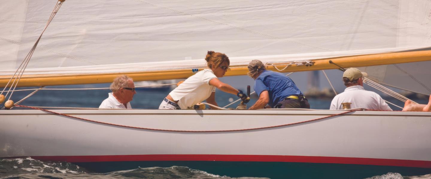 Sailboat with four people adjusting sails.