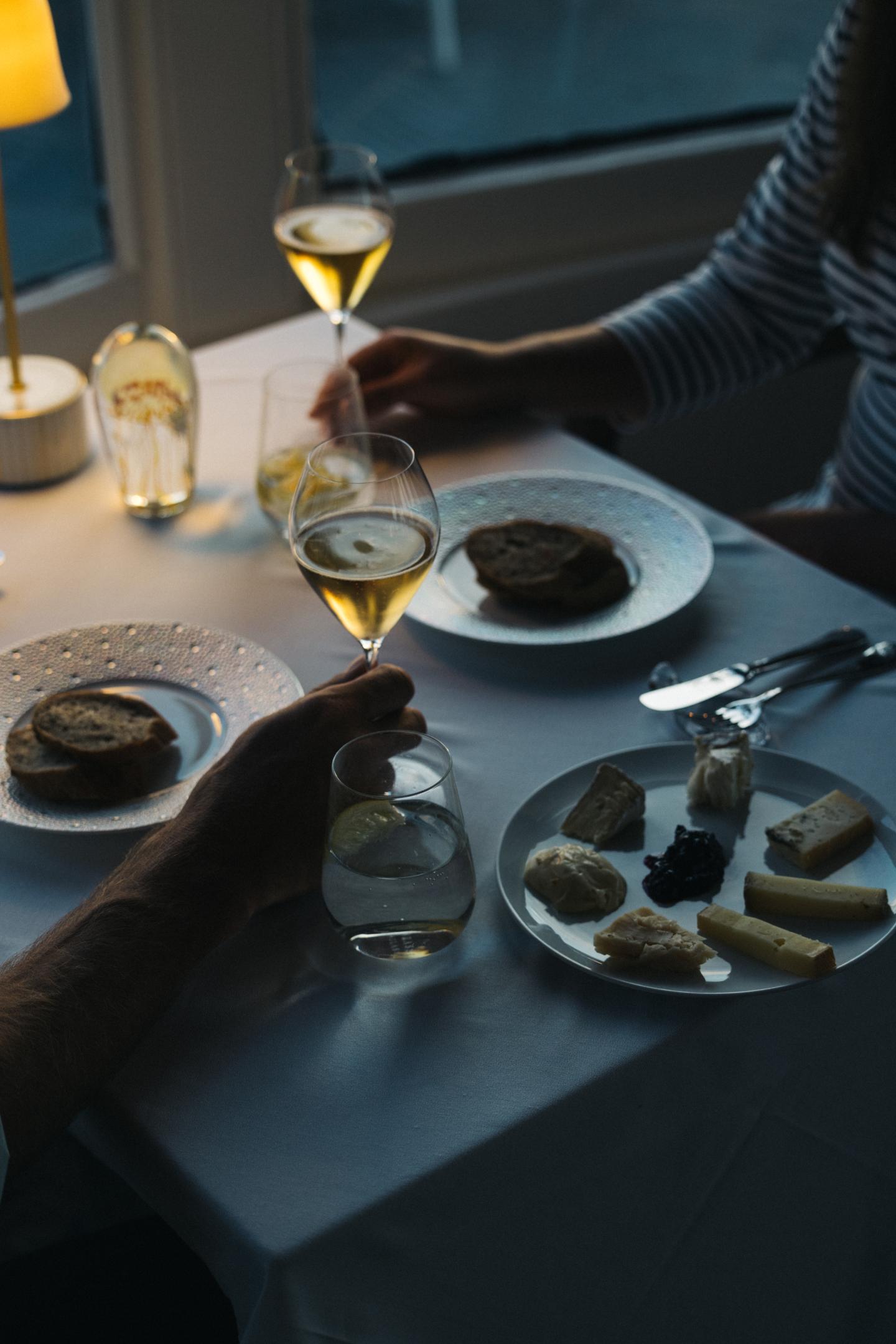 Dining with wine and cheese at a candlelit table.