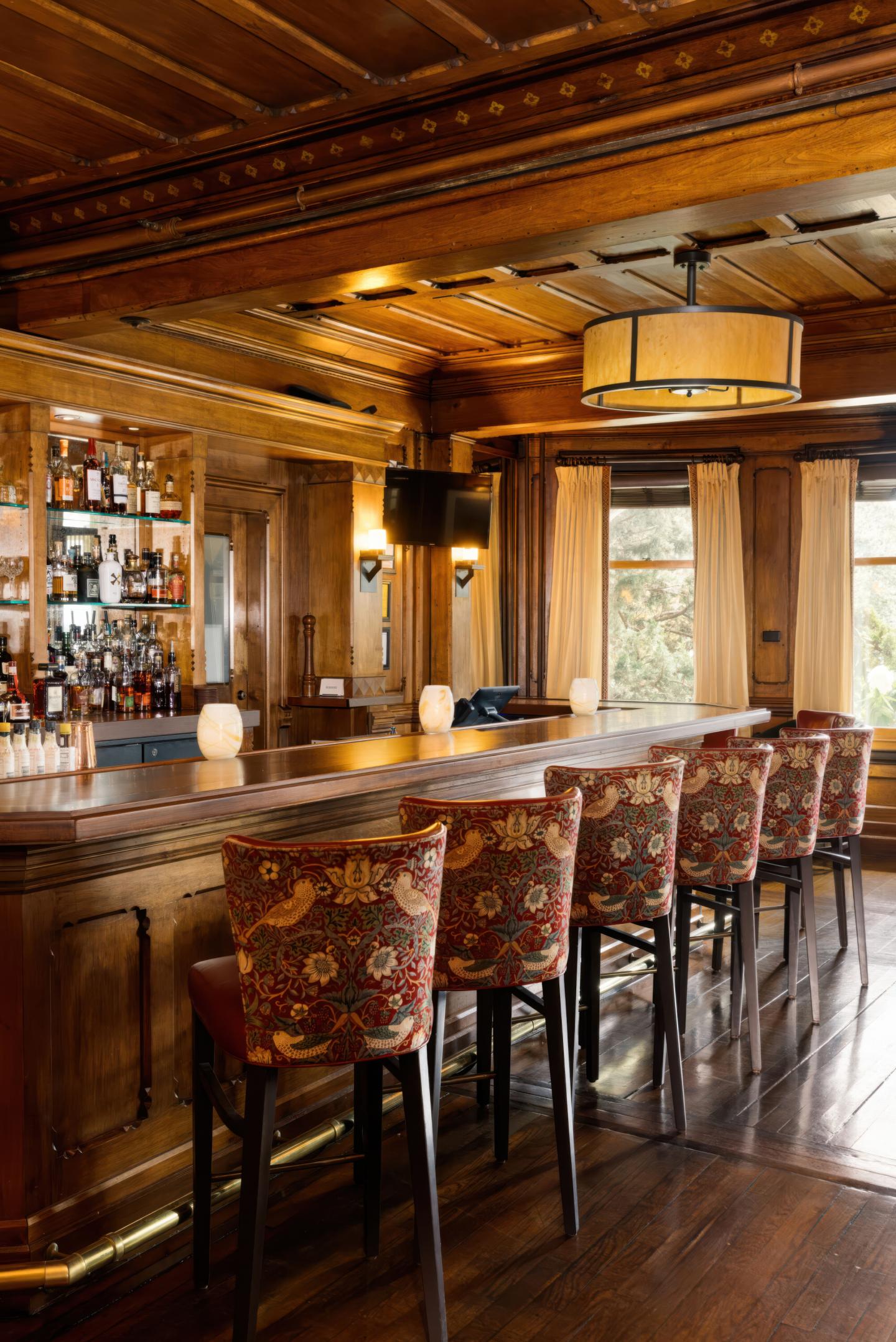 Cozy wooden bar interior with decorative chairs and warm lighting.