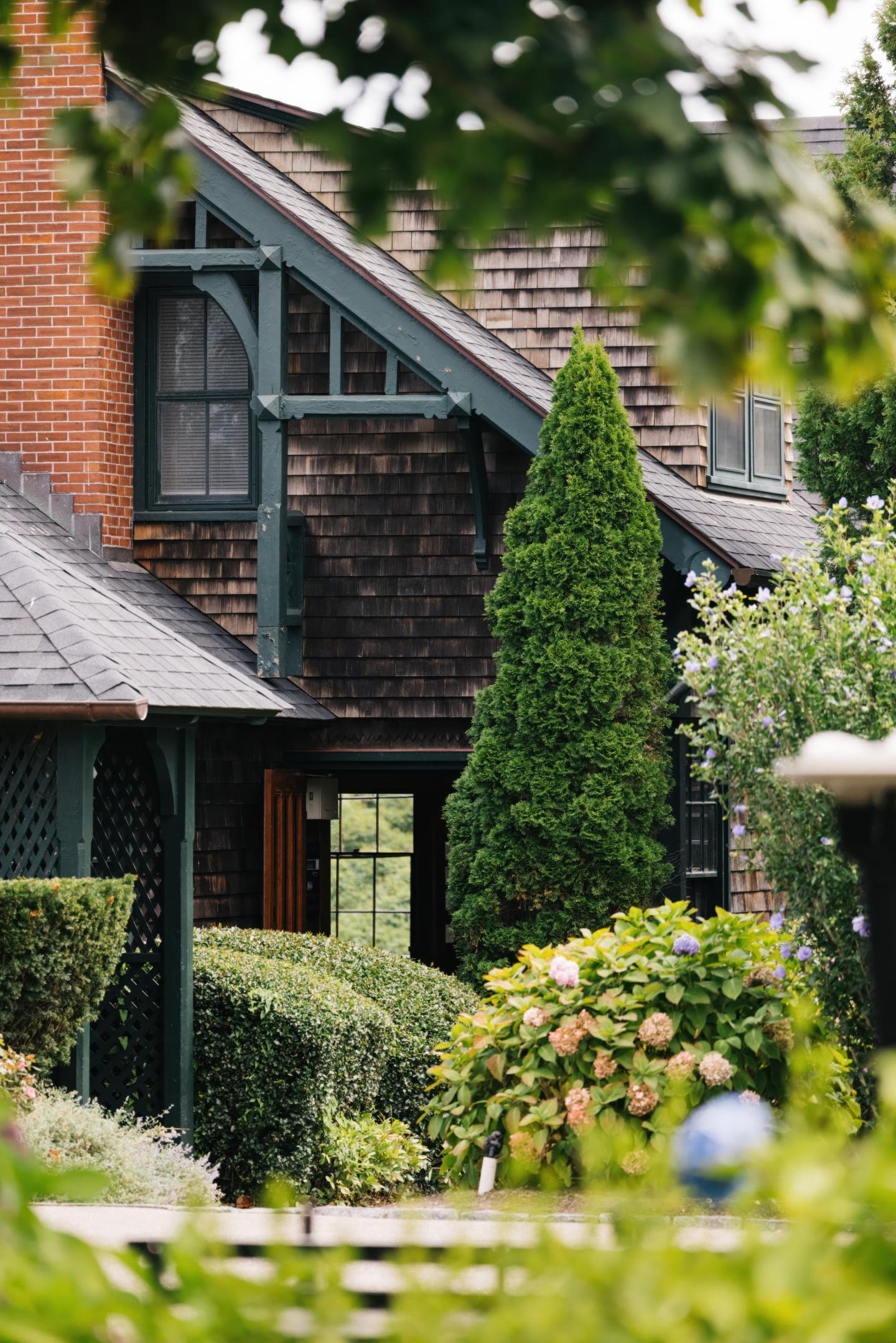 Cozy house with greenery and a small garden in front.