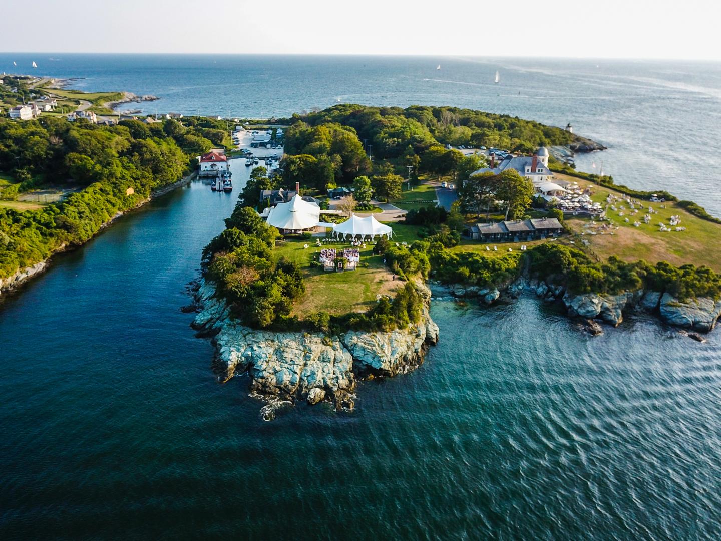 Aerial view of a small lush island surrounded by blue water.
