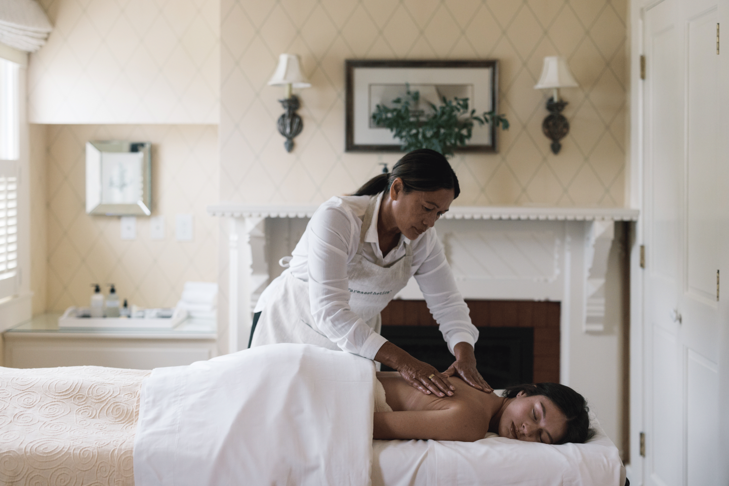 Massage therapist working on a client's back in a cozy room.