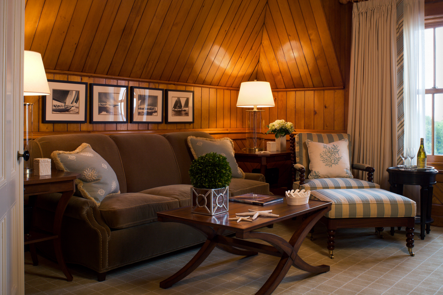Cozy living room with brown sofa, striped chair, and warm lighting.