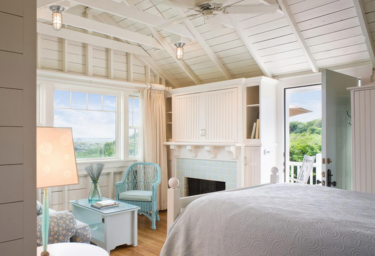 Cozy bedroom with white walls, large window, and blue furniture.