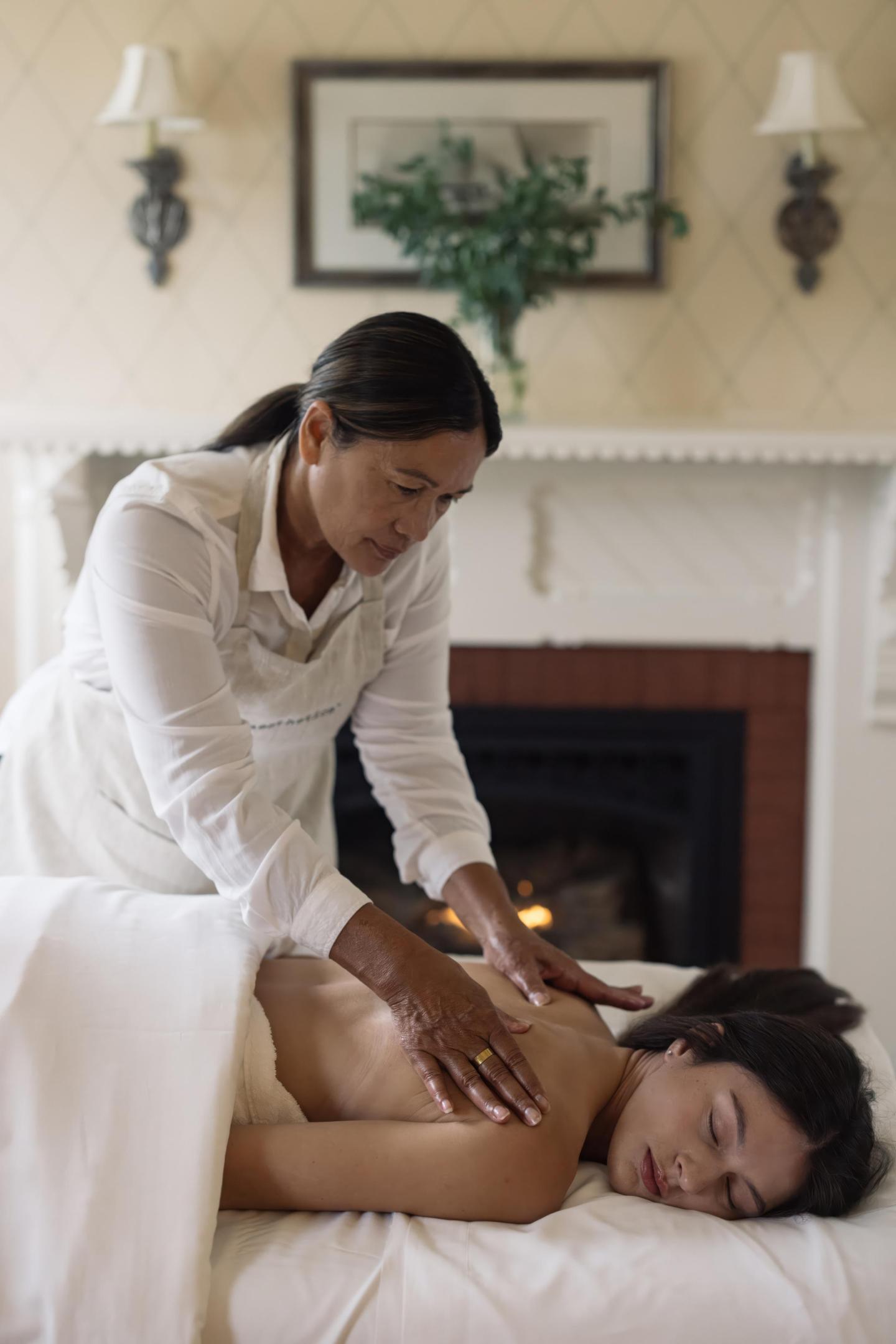 Woman receiving a back massage in a cozy room.