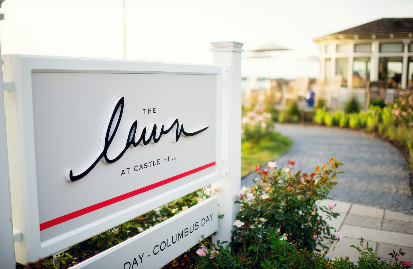 Sign for "The Lawn" next to a garden path, building in the background.