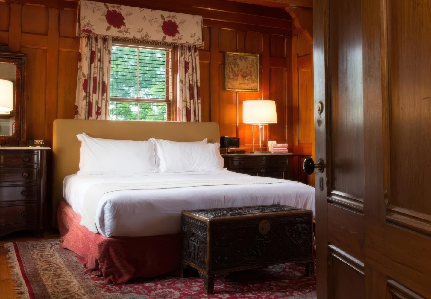 Cozy bedroom with a double bed, wooden paneling, and decorative lamps.