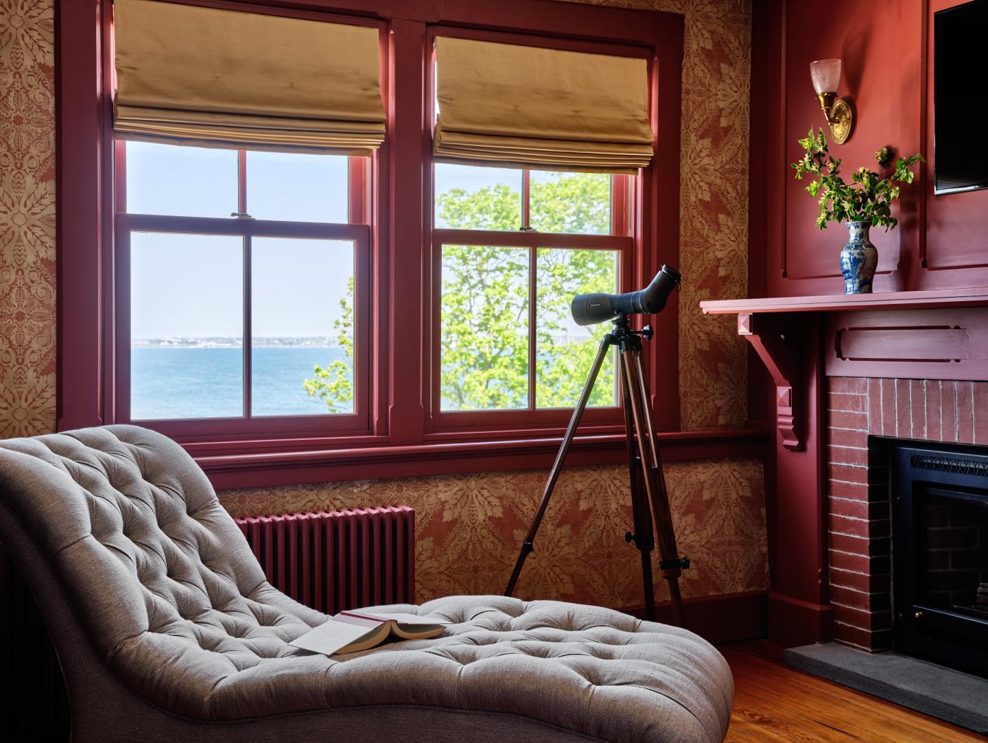 Cozy room with a chaise lounge, telescope, and ocean view.
