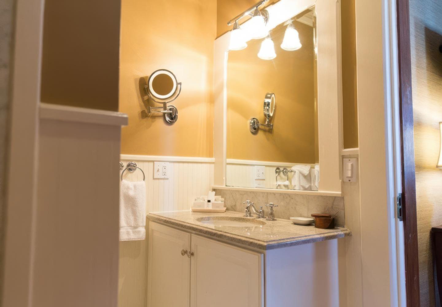 Bathroom vanity with mirror, lights, and towel on the left.