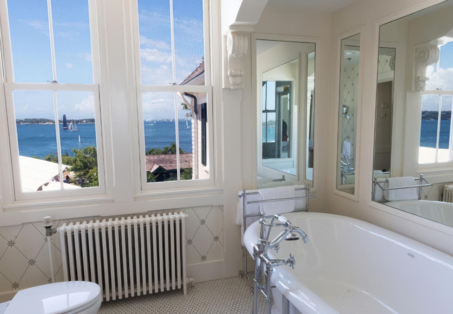 Elegant bathroom with ocean view and clawfoot tub.