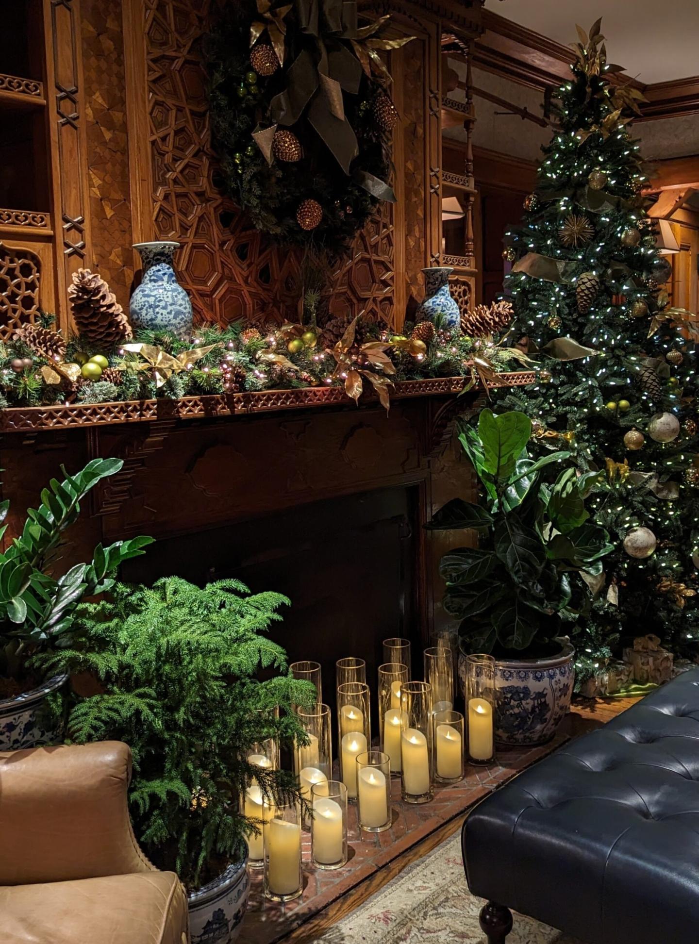 Festive room with Christmas tree, candles, and decorated mantel.
