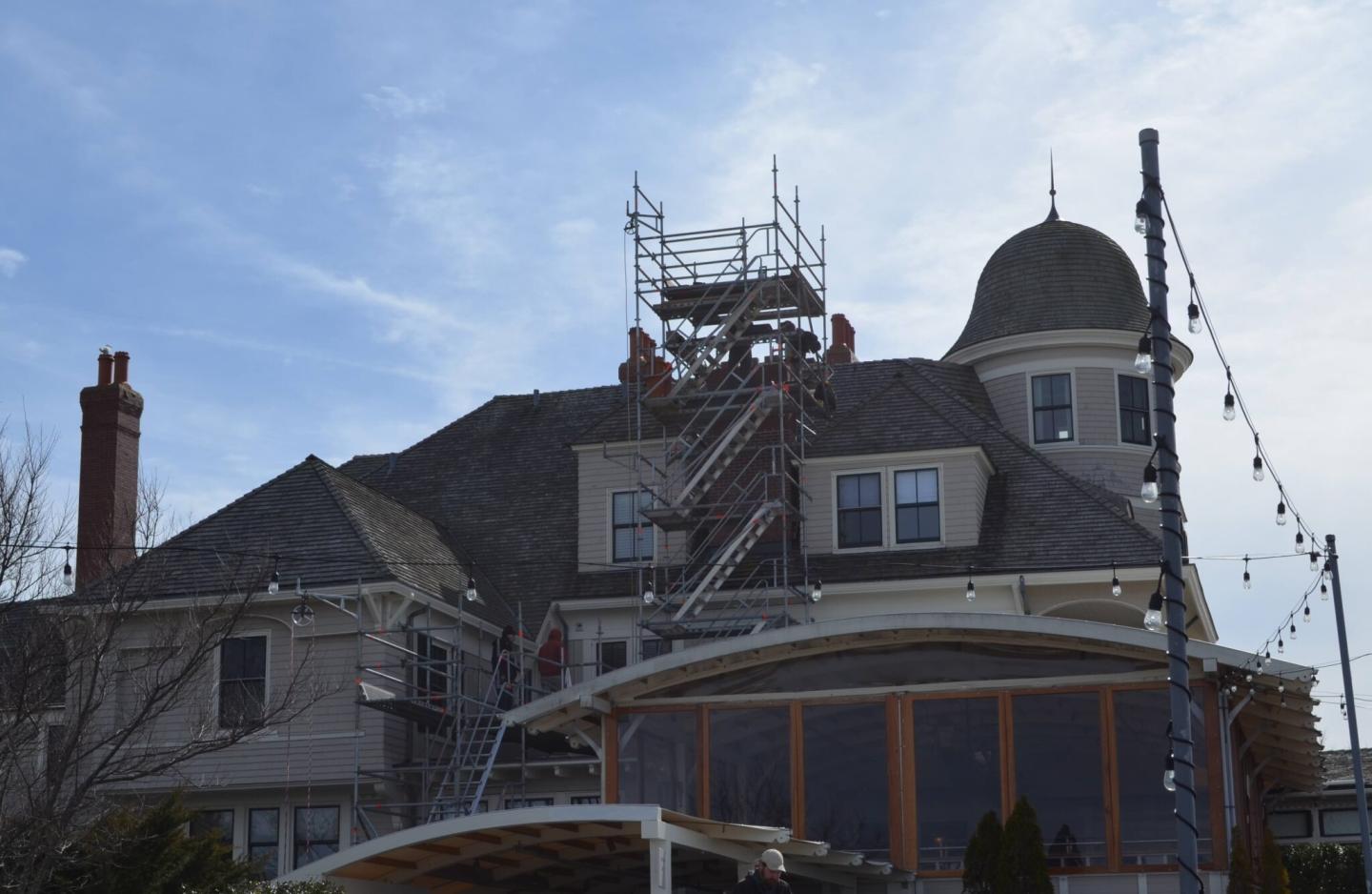 Historic house with scaffolding under a clear blue sky.
