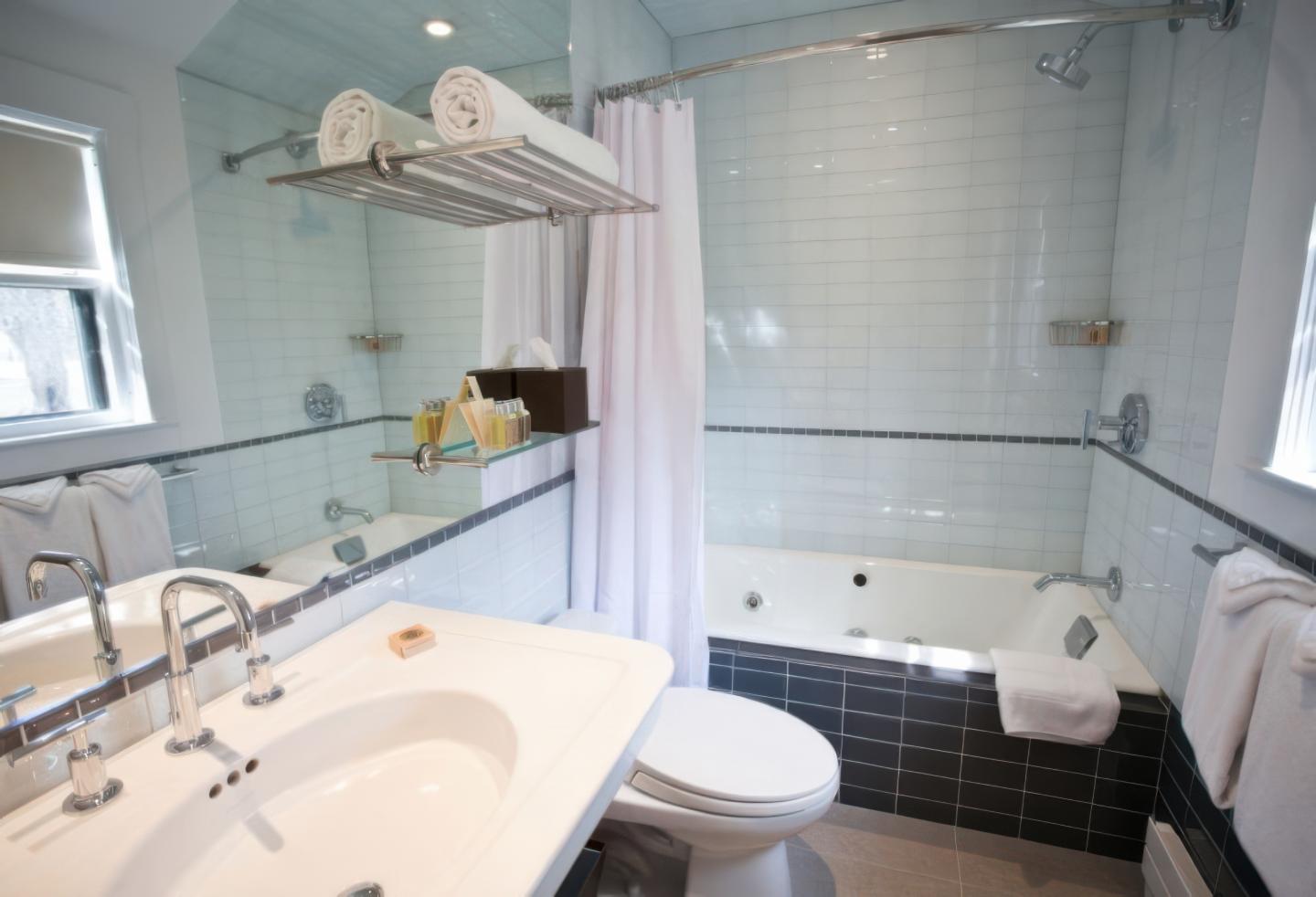 Elegant bathroom with sink, toilet, tub, and fluffy towels.