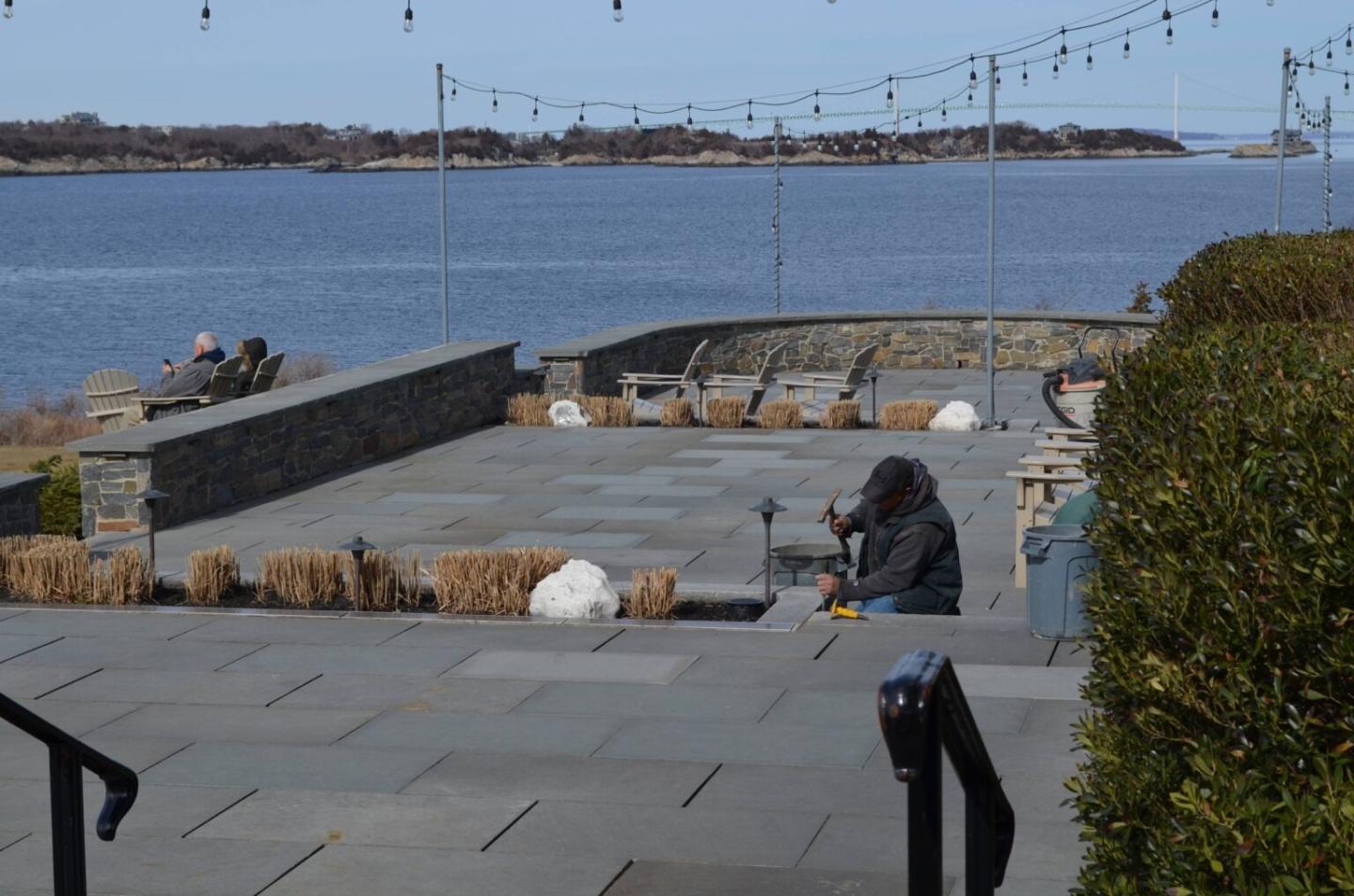 Terrace overlooking the sea with empty seating and string lights.