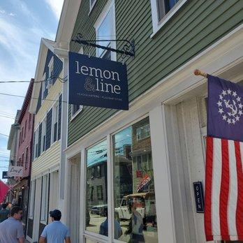 Street view of a shop with flags and people walking.