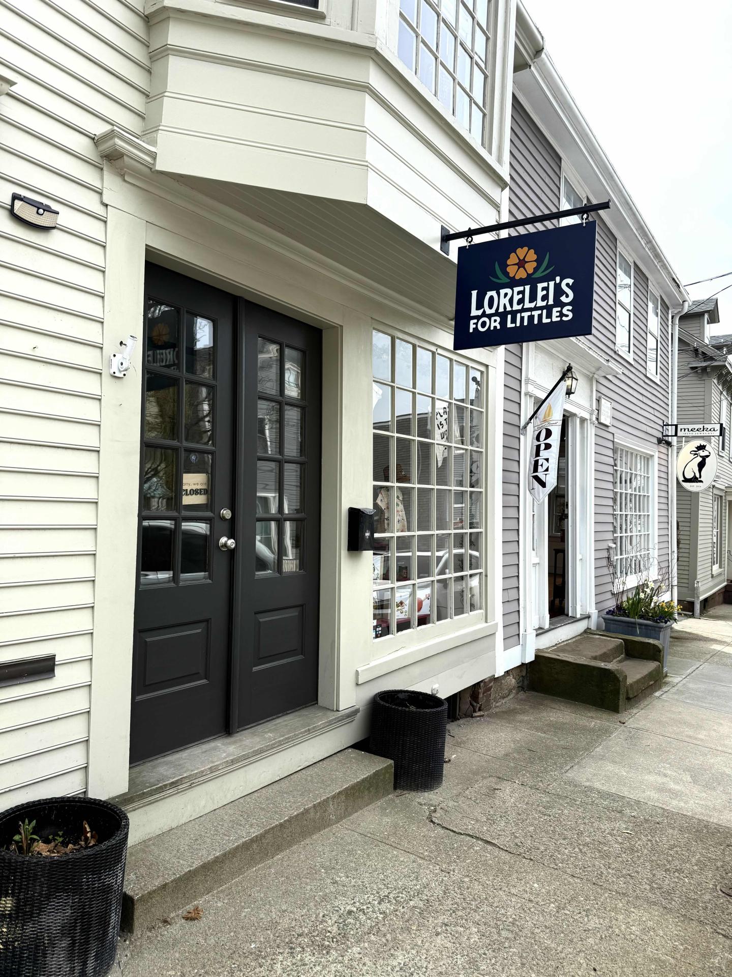 Storefront with dark double doors and a hanging sign.