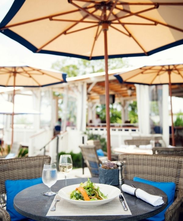Table with dishes and glassware under umbrella at Castle Hill Inn in Newport, RI