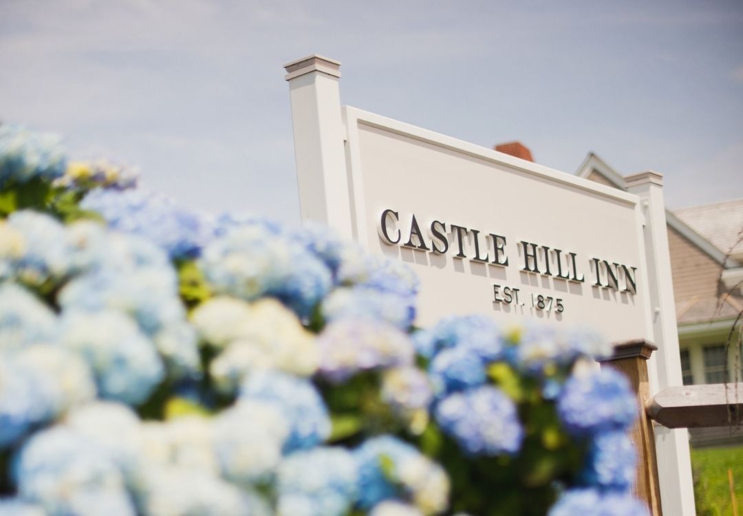Castle Hill Inn sign in front of bunch of blue flowers at Castle Hill Inn in Newport, RI
