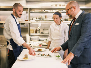 Chef Dylan in the kitchen with Marie and Director of Restaurants Michael Doctor