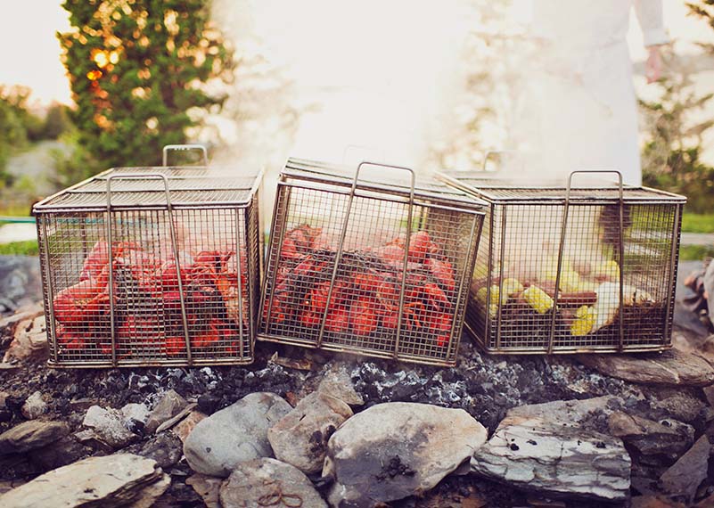 Lobsters, corn and sausage cooking in baskets over open fire at Castle Hill Inn in Newport, RI