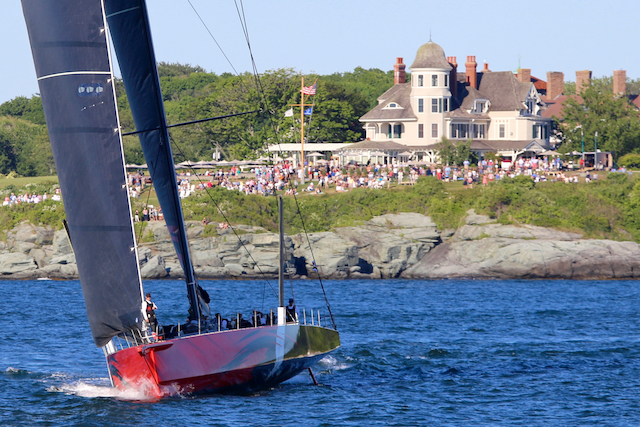 Sailboat with people on it on water with group watching from shore near Castle Hill Inn in Newport, RI