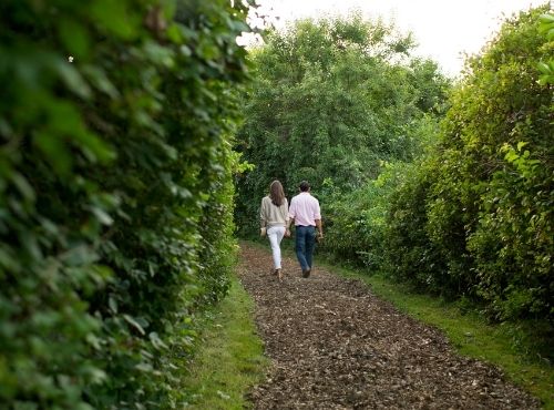 Two people walking in forest on dirt pathway near Castle Hill Inn in Newport, RI