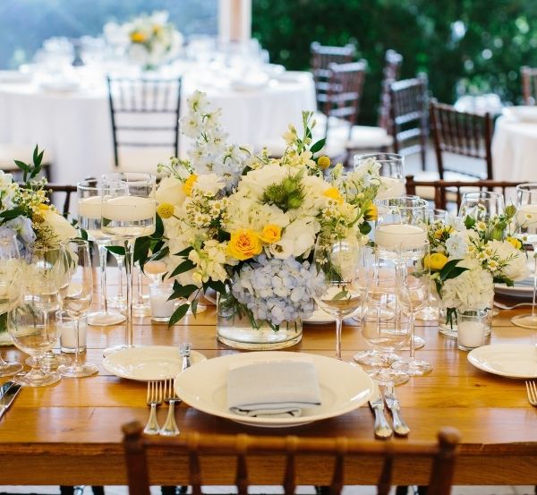 Yelow floral arrangement next to glassware on top of wooden table at Castle Hill Inn in Newport, RI